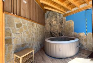 a large tub in a room with a stone wall at Casa Tio Paco in Cazorla
