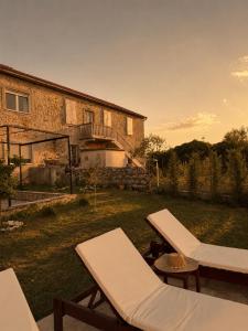 a house with a yard with two lounge chairs at Maison Des Oliviers in Herceg-Novi