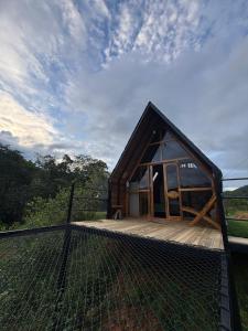 a small cabin with a fence on a deck at Ecolodge Ix Cacao in San Carlos