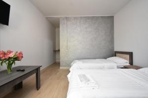 two beds in a room with a table and flowers at Zvartnots in Zvartnots International Airport