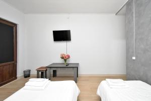 a room with two beds and a table with a tv at Zvartnots in Zvartnots International Airport +16 photos