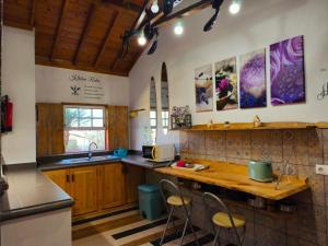 a kitchen with wooden cabinets and a counter with stools at De Baixo Da Ponte in Biscoitos