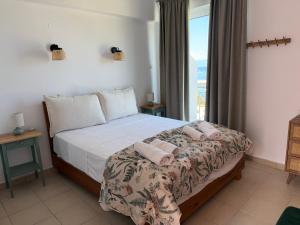 a bedroom with a bed with a view of the ocean at Angelika Rooms in Longá