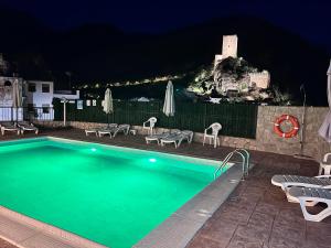 a swimming pool with chairs and umbrellas at night at Casa Antonia in Cazorla
