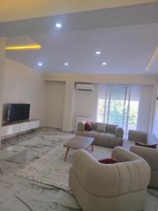 a large living room with couches and a tv at Apparemment valmascort annaba in Annaba