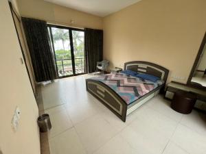 a bedroom with a bed and a large window at Tranquil villa Raichak in Diamond Harbour