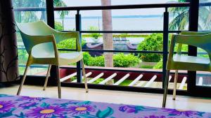 two chairs sitting in front of a window at Tranquil villa Raichak in Diamond Harbour
