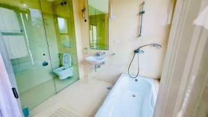 a bathroom with a tub and a toilet and a sink at Tranquil villa Raichak in Diamond Harbour +14 photos