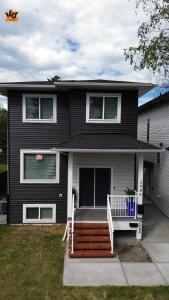 a black house with a porch and a white deck at The Ivory house in Prince George +2 photos