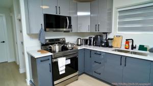 a kitchen with white cabinets and a stove top oven at The Ivory house in Prince George