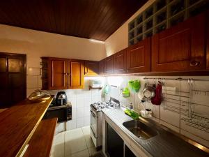 a kitchen with a sink and a stove top oven at Casa da Neuza in Resende