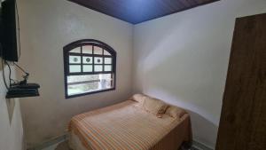 a small room with a bed and a window at Casa da Neuza in Resende +5 photos