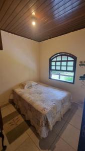 a bedroom with a bed in a room with a window at Casa da Neuza in Resende