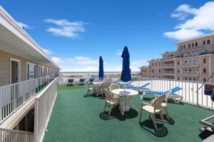 a balcony with tables and chairs and umbrellas at Astronaut Motel in Wildwood Crest