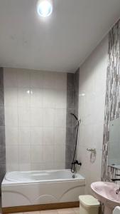 a white bathroom with a tub and a sink at Najma Roz Hotel in Abha +23 photos