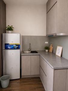 a kitchen with a white refrigerator and a sink at U-ViVu Homestay Ocean Park 3 Hưng Yên in Ðình Loan