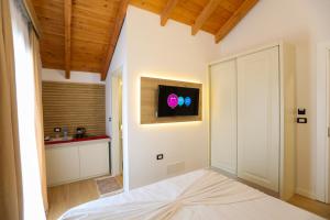 a bedroom with a door with a television on the wall at Guesthouse Micaj HORA in Himare +11 photos