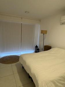 a bedroom with a white bed and a window at Monoambiente in Venado Tuerto