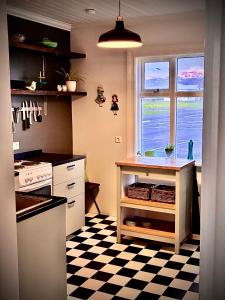 a kitchen with a checkered floor and a window at Seaside Retreat, Glacier View in Hellissandur