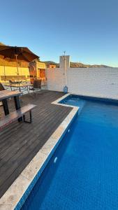 a swimming pool with a picnic table and an umbrella at Apartamento com piscina privativa 7 minutos da basílica in Aparecida