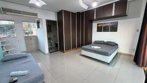 a bedroom with two beds and a couch in it at Apartamento com piscina privativa 7 minutos da basílica in Aparecida +14 photos