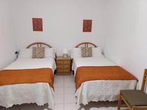 two beds sitting next to each other in a room at Hostal La Madrileña in La Gudiña +7 photos