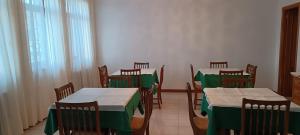 a dining room with tables and chairs with green table cloth at Hostal La Madrileña in La Gudiña