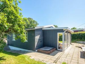 a blue house with a porch and a patio at 4 person holiday home in Haderslev in Haderslev +15 photos