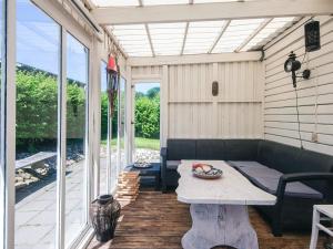 a screened in porch with a couch and a table at 4 person holiday home in Haderslev in Haderslev