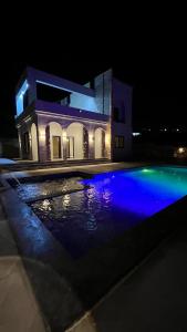 a house with a swimming pool at night at ڤيلا الكرم in Jerash