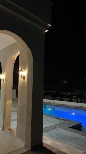 a view of a swimming pool at night at ڤيلا الكرم in Jerash +7 photos