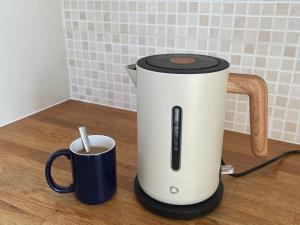 a coffee maker and a cup on a counter at The Nook in Bedford