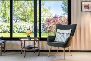 a living room with a chair and a table and windows at FY348-Svendborg-Storkenaebsvej-1 in Svendborg +16 photos