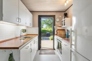 a kitchen with white cabinets and a door to a yard at FY348-Svendborg-Storkenaebsvej-1 in Svendborg