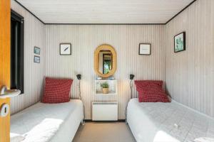 a bedroom with two beds and a mirror at FY348-Svendborg-Storkenaebsvej-1 in Svendborg