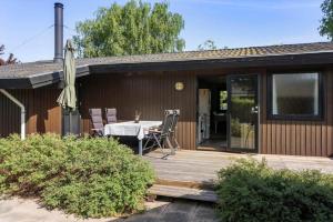 a house with a wooden deck with a table and an umbrella at FY348-Svendborg-Storkenaebsvej-1 in Svendborg