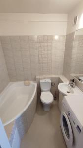 a bathroom with a tub and a toilet and a sink at SkyView Studio Łódź - 11th Floor - Free Parking in Łódź
