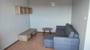 a living room with a blue couch and a table at SkyView Studio Łódź - 11th Floor - Free Parking in Łódź