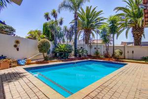 a swimming pool in a yard with palm trees at Kempton kingdom in Kempton Park +2 photos