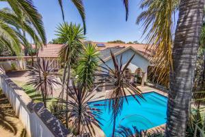 a villa with a swimming pool and palm trees at Kempton kingdom in Kempton Park