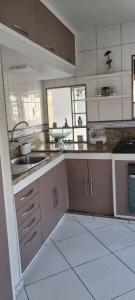 a kitchen with a sink and a counter top at Quarto Pernoite Costa do Sol in Macaé