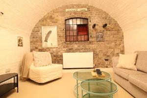 a living room with a couch and a glass table at The Ironbridge Lockup - Former Cell in Ironbridge