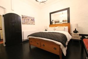 a bedroom with a large bed with a large mirror at The Ironbridge Lockup - Former Cell in Ironbridge
