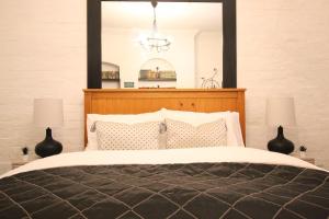 a bedroom with a bed with a mirror above it at The Ironbridge Lockup - Former Cell in Ironbridge
