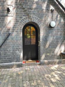 a brick wall with a black door with an archway at The Ironbridge Lockup - Former Cell in Ironbridge +66 photos