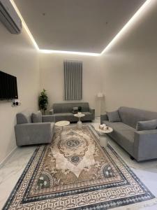 a living room with two couches and a rug at المجيدل للشقق المفروشة in Arar