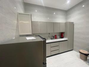 a kitchen with a refrigerator and a counter top at المجيدل للشقق المفروشة in Arar