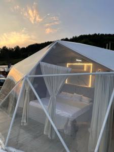a white tent with a bed inside of it at Džipsi glamping resort in Sarajevo