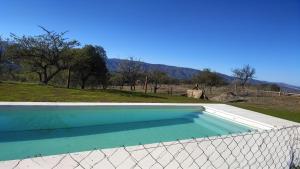an empty swimming pool with a fence around it at Cabañas Altos del Sauce in Villa General Belgrano