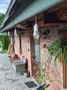 a brick building with a patio with chairs and lights at Studio Lawendowe Ranczo in Zawichost